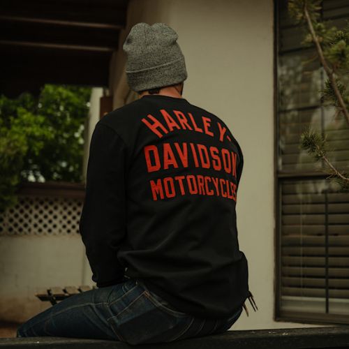 shop Harley Davidson Civitanova | Maglia da uomo Men’s Racer Font Henley Maglia nera a maniche lunghe modello Henley Harley-Davidson con tre bottoni e logo Bar & Shield arancione ricamato sul petto. indossato dietro